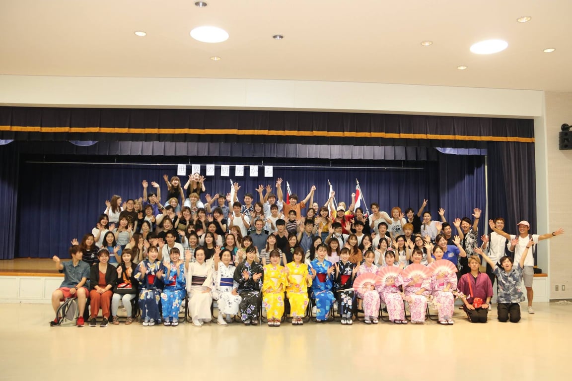 Group photo. See the black shirt guy who’s two rows behind the 2 yellow kimono girls? I’m to the left of him.