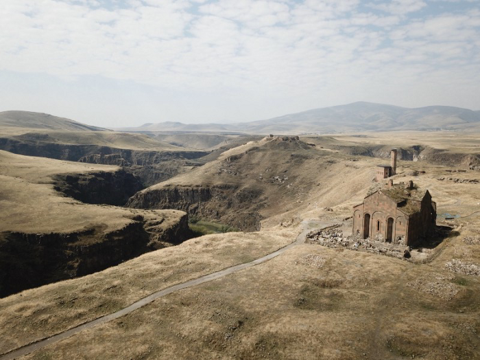 Ani, Turkey. 河谷左側為東方，是現今的亞美尼亞。河谷右側為西方，是現今的土耳其。圖中由右至左為：Cathedral of Ani 教堂、The mosque of Manuchihr 清真寺、The Citadel of Ani 山丘要塞。