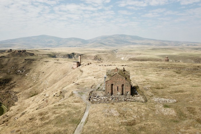 Ani, Turkey. 用空拍機從東方往正西方拍，可以看出整座城市的建築幾乎已經消失，彷彿荒野上除了殘存的幾座大型建築外不曾出現過其他的事物。在遠方山腳下的幾座大約在四、五公里之外