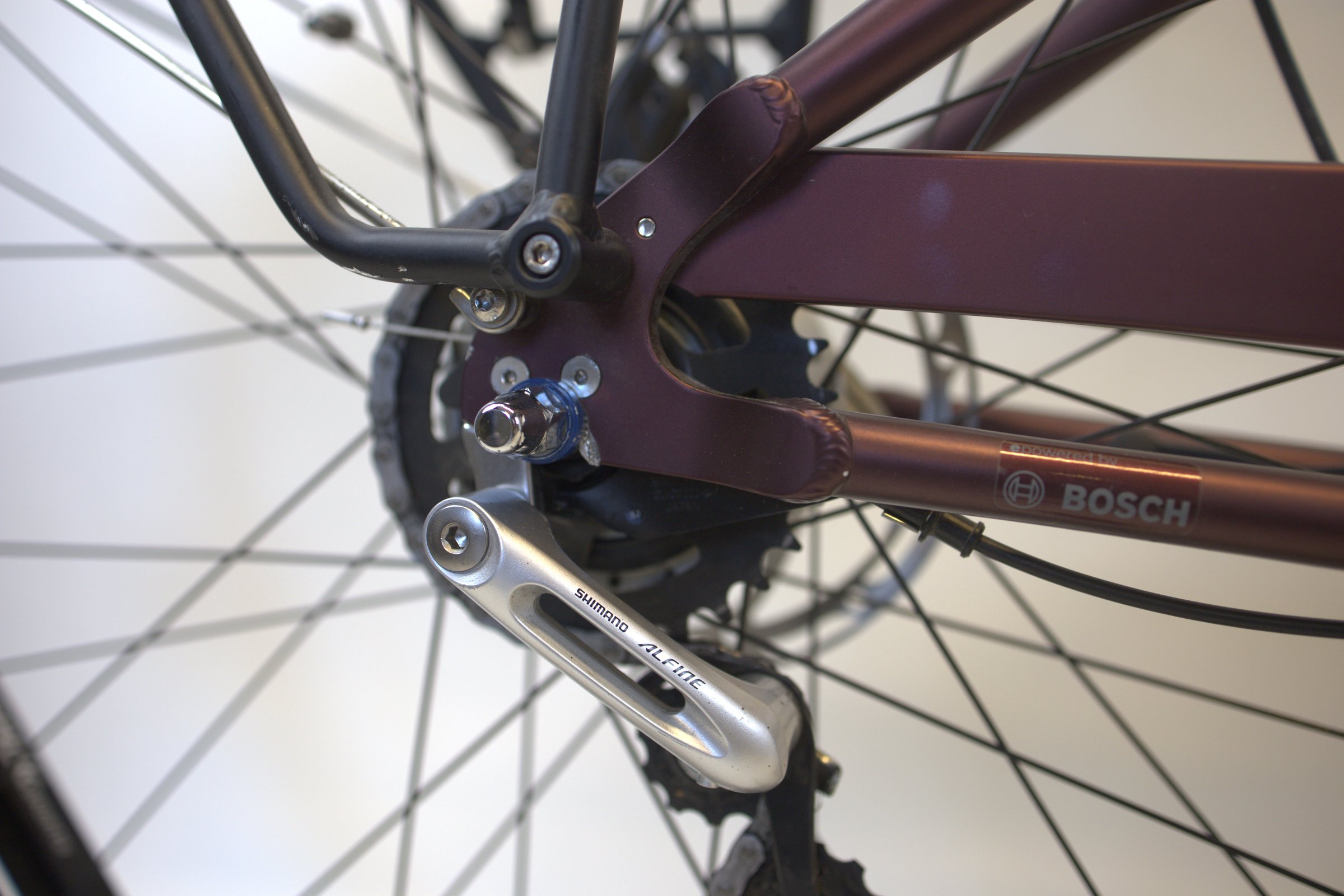 Burgunder Electra Townie Go detalj av bakhjul og girsystem.