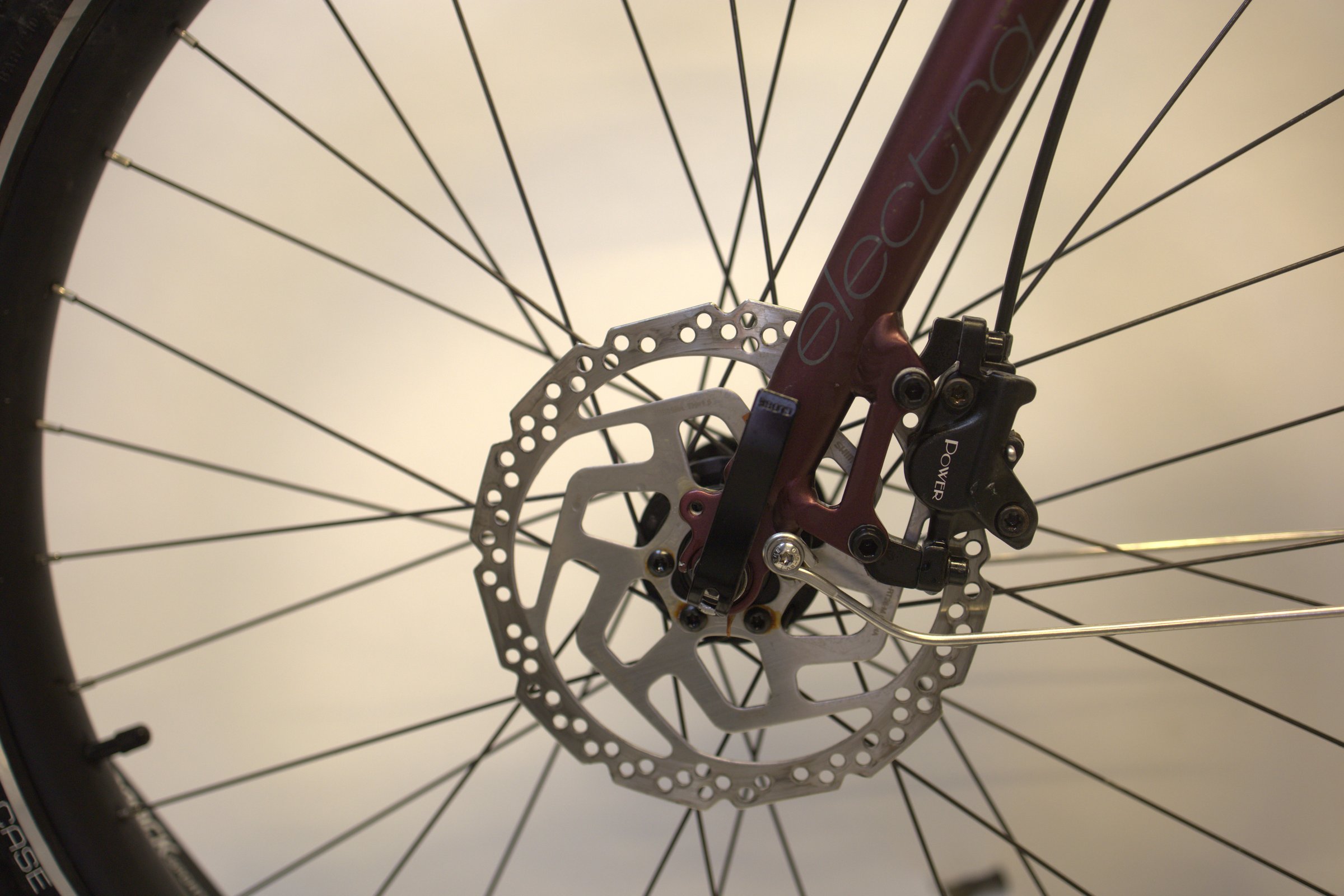 Burgunder Electra Townie Path Go! 10D EQ foran på brems og hjul.