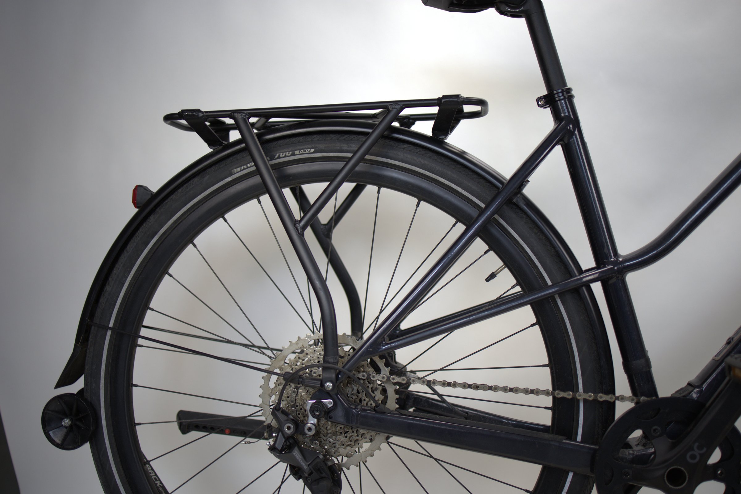 Svart Orbea VIBE H30 bakhjul med bagasjebærer og kjede.