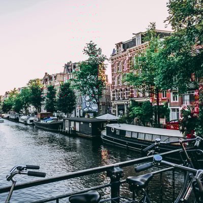 Bicycles parked beside a scenic canal in Amsterdam
