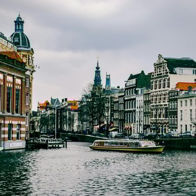 Boat cruising through a quiet canal in Amsterdam