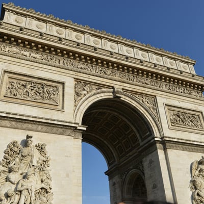 Close-up of the Arc de Triomphe with detailed stone carvings and nearby traffic