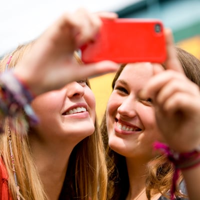 Two smiling students taking a selfie, representing the rewarding and fun experiences teachers earn by traveling free with their groups.