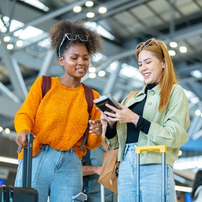 Students at the airport reviewing travel details, representing optional upgrades like cancellation protection
