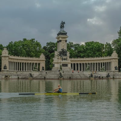 Peaceful lake view at El Retiro Park in Madrid with small boats drifting across the water