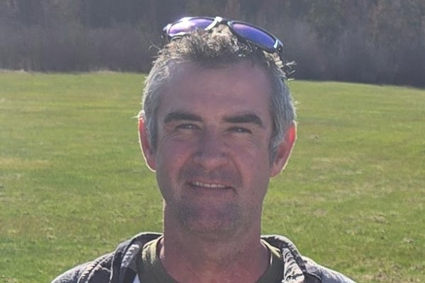 Lee Bernard profile picture. Middle-aged man with white and black hair posing for a picture with a grassy field in the background