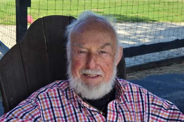 Paul Bernard profile picture. Elderly gentleman with white hair and beared wearing a red, white, and blue checkered shirt