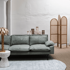 sidetable van hkliving in het wit met een groene bank, grijze vloerkleed en accessoires