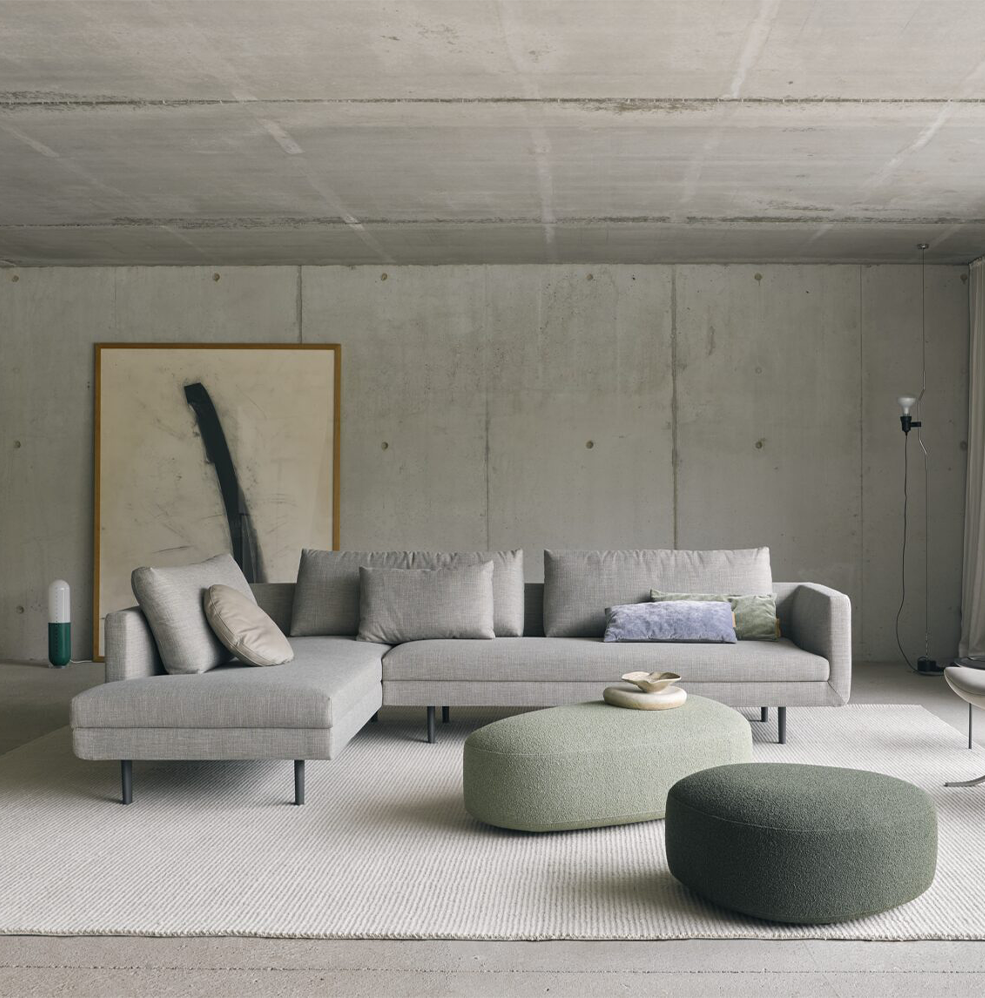 poef kivi triangle van EYYE in stof wit met grijze bank en grijze vloerkleed