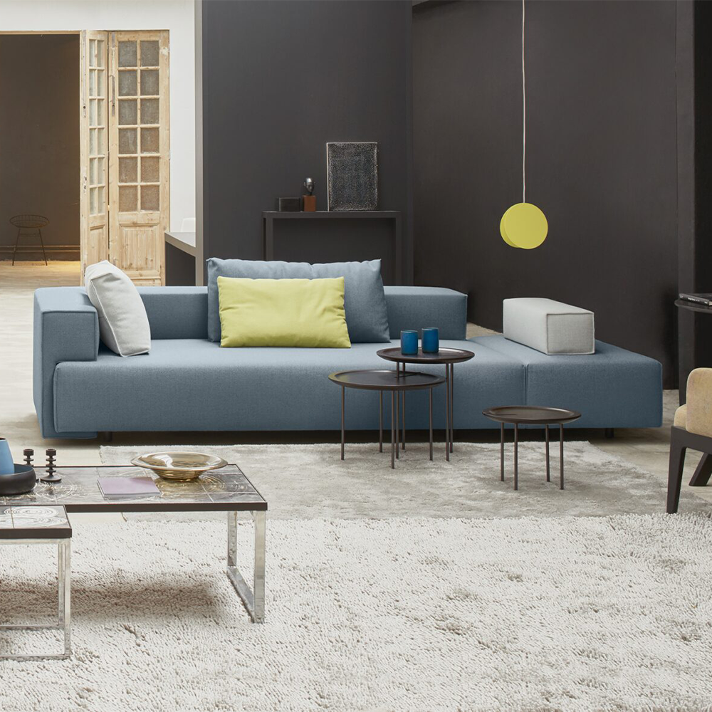 divan cella van EYYE met zwarte ronde poten in het donker groen met salontafel en vloerkleed