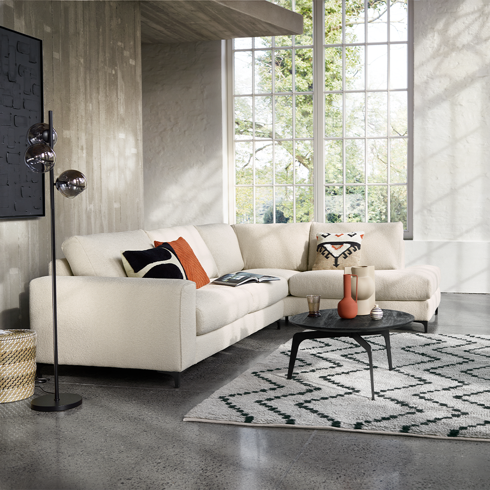 hoekbank luanta van inhouse boucle beige stof met zwarte poten met zwarte vloerlamp