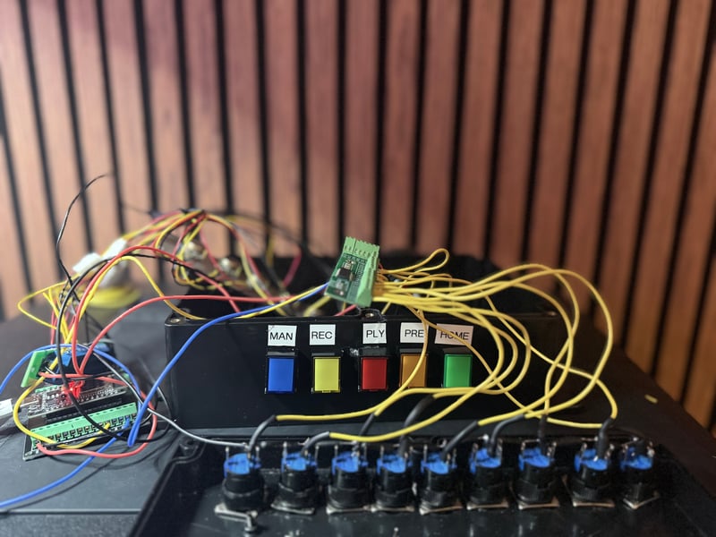 Control console interior showing 14 button wiring harness with yellow signal wires routed to MCP23017 breakout