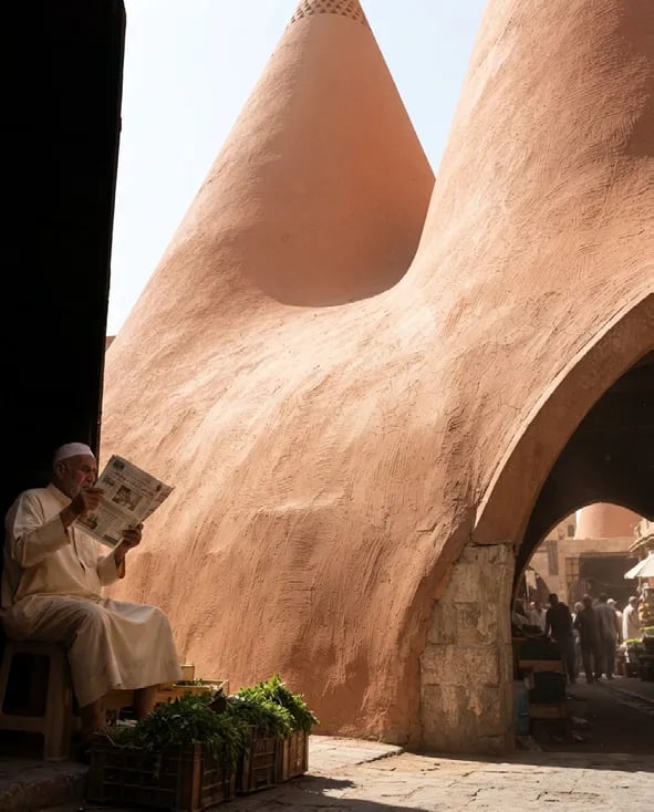 Man reading beneath terracotta cones
