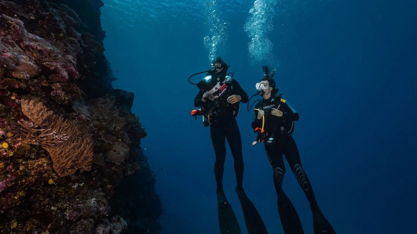 Two scuba divers beside the coral wall at Paul's Rock, Vanuatu