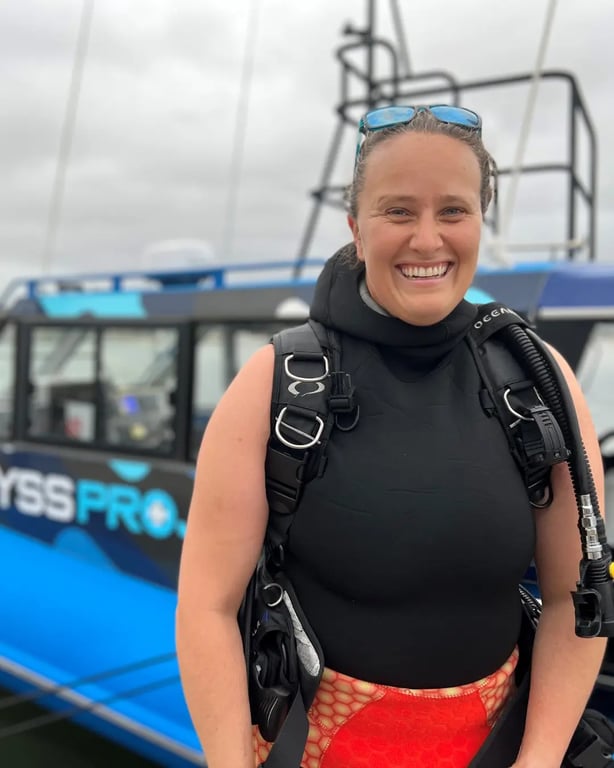 Smiling scuba diver beside the Abyss Pro dive boat