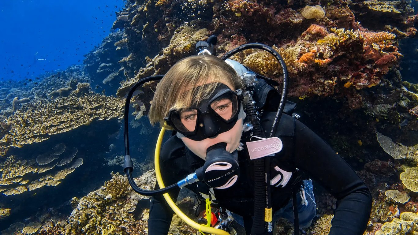 Scuba diver beside a colourful coral wall at Moso Island, Vanuatu