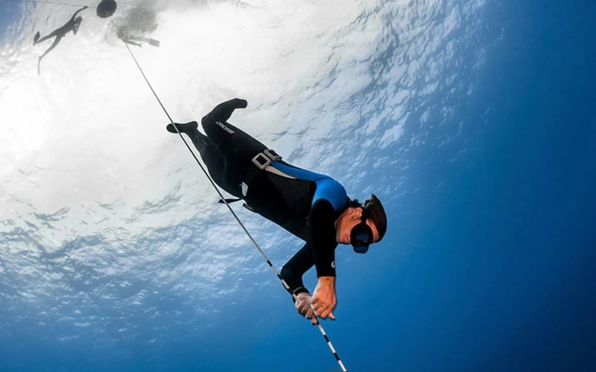 Freediver training on a line in clear blue Vanuatu water