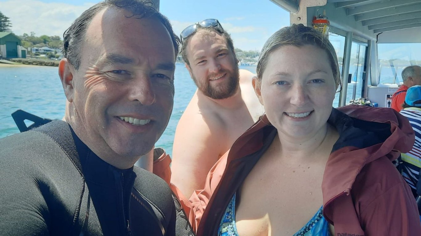 A group of certified divers gathers on a boat, preparing their scuba gear for an upcoming guided dive at local dive sites. The atmosphere is filled with excitement as they check their dive equipment, ready to explore the underwater world and encounter diverse marine life.