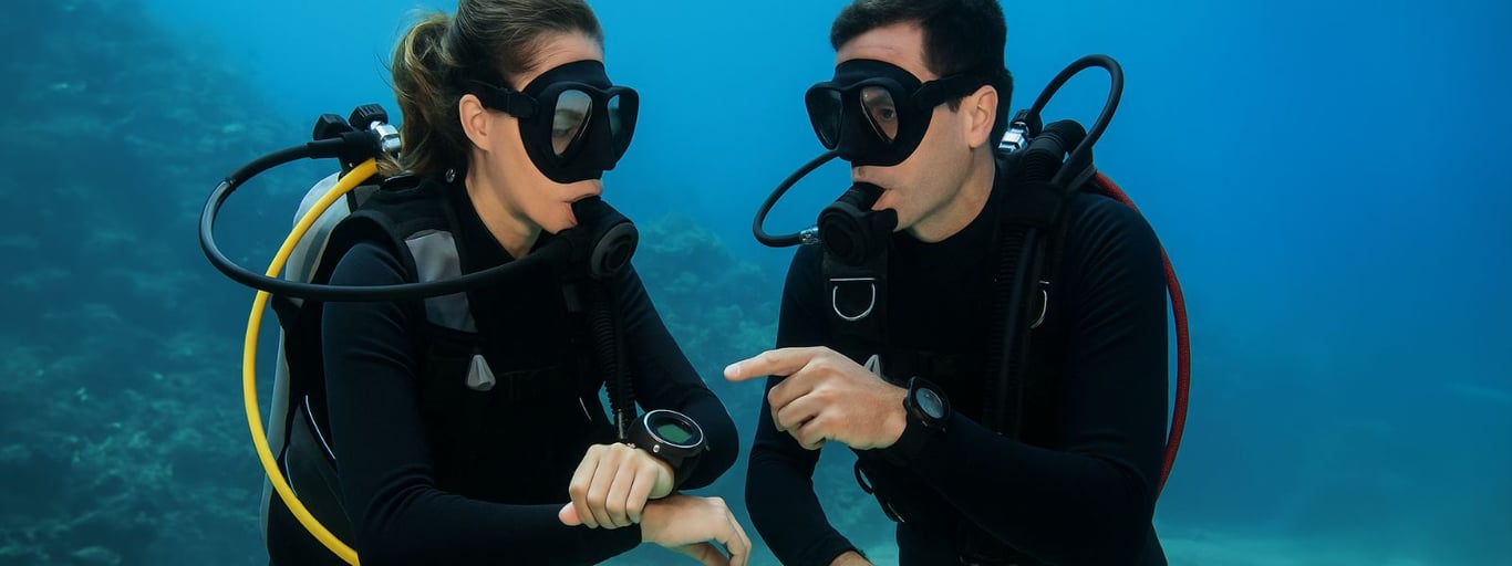 Instructor showing dive computer underwater