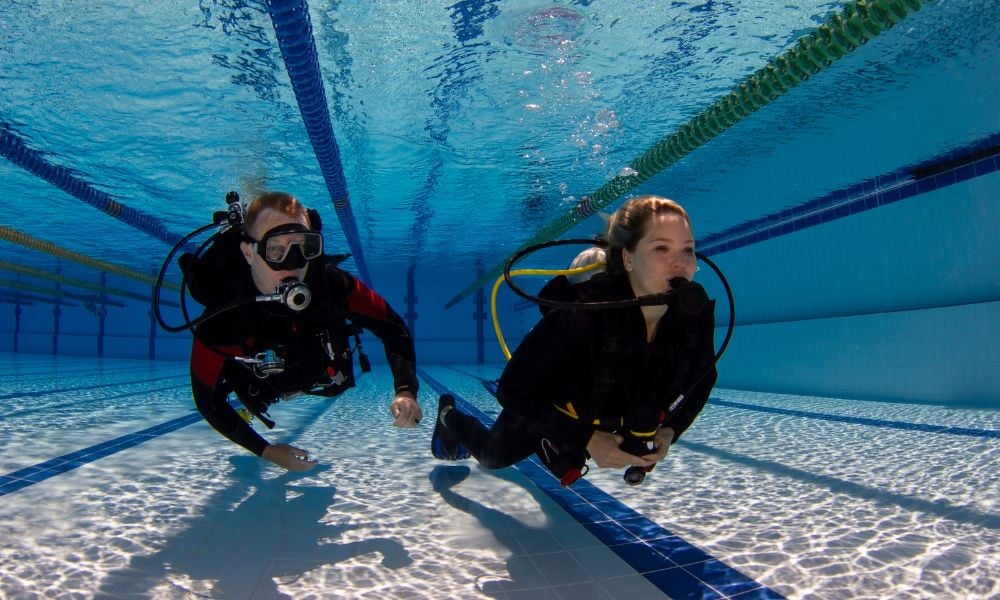 A beginner divers receiving instruction at a swimming pool, emphasizing personalized attention.