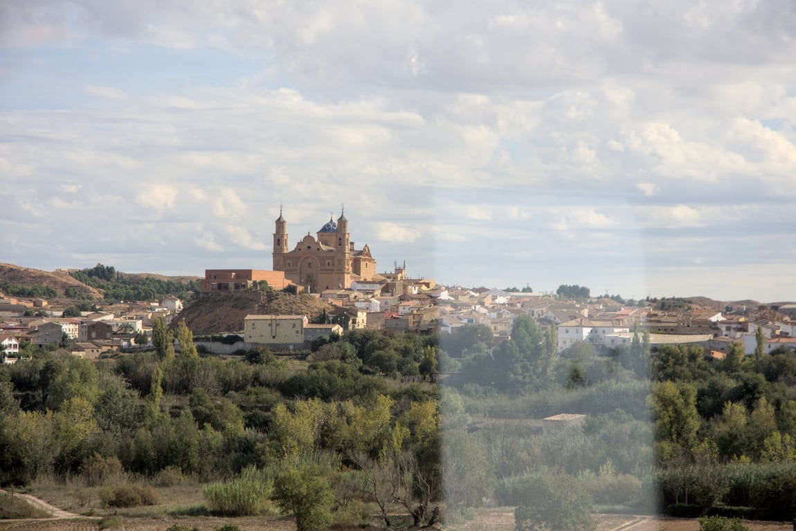 A castle atop a hill in the middle of a village