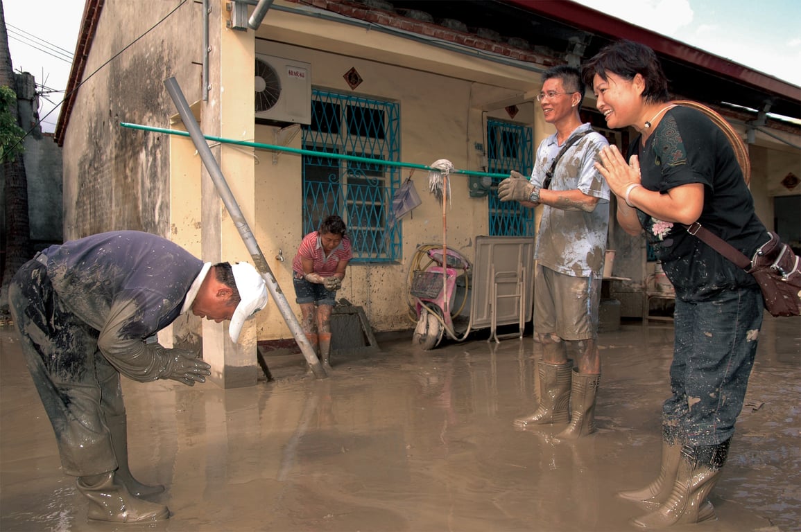 協助莫拉克颱風（八八水災）災民清理家園後，志工的雙手沾滿了汙泥，仍謙卑的合十道感恩。