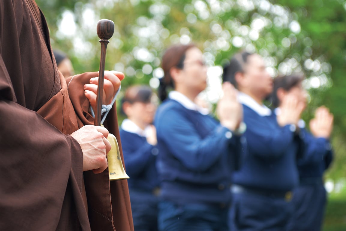 常住師父手持法器(鐘)，虔誠領眾朝山。