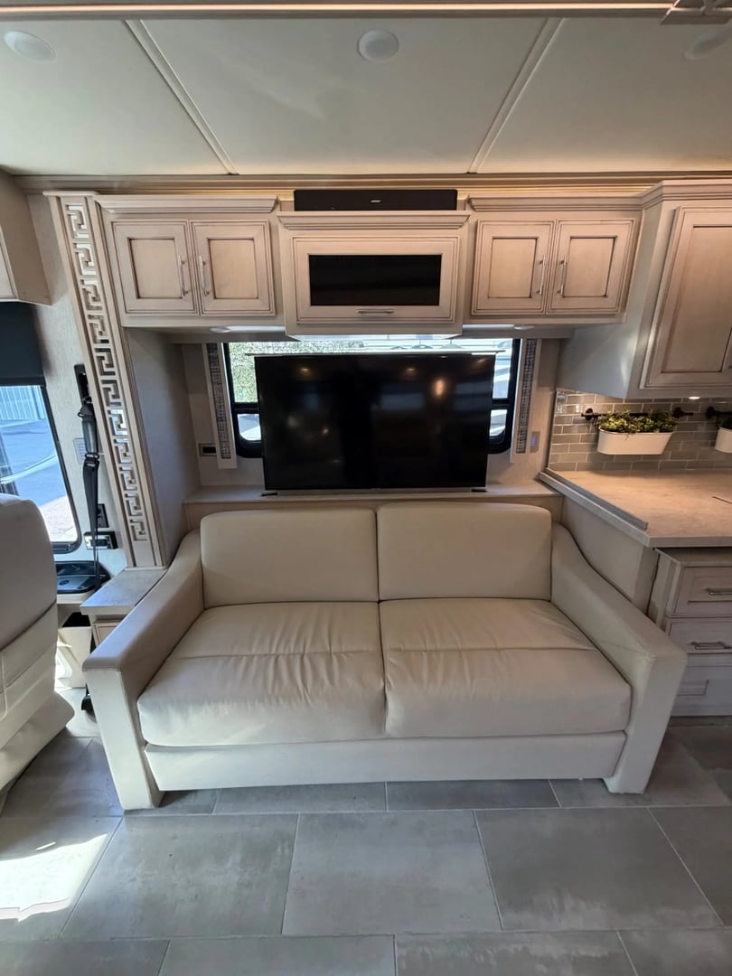 Sofa with automatic TV lift facing recliners