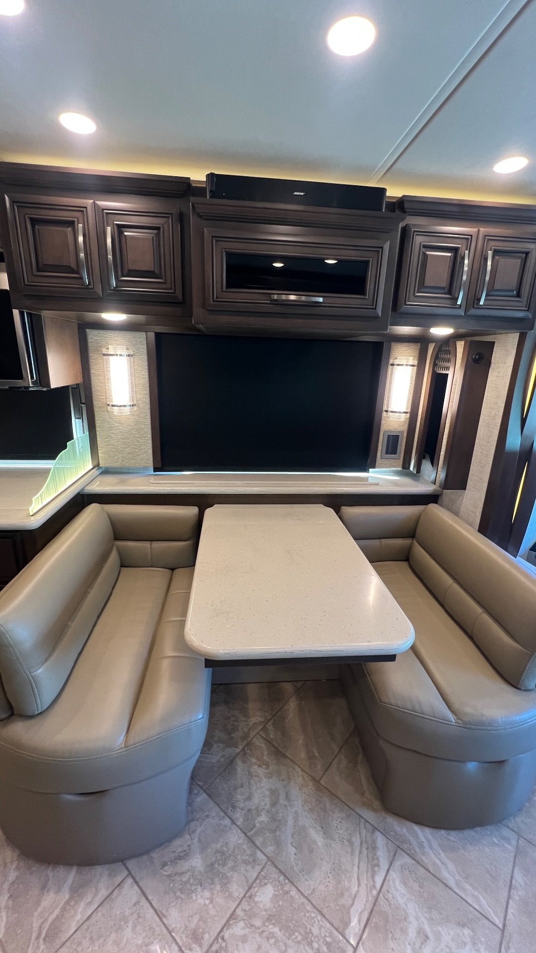 2021 Newmar New Aire 3541 — U-shaped dinette with padded seating, tabletop, overhead cabinets, and a large mounted television