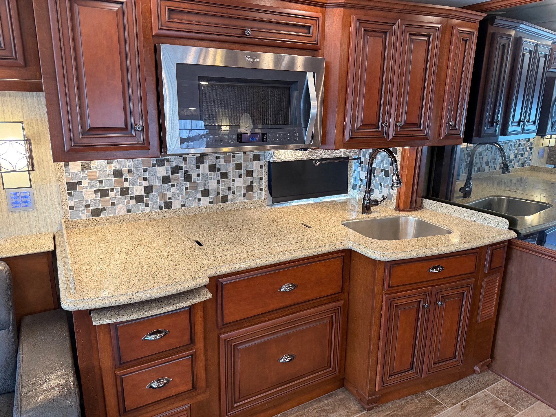 2017 Newmar Dutch Star 4369 — Class A kitchen with stainless microwave, double sink, expansive counter, mosaic backsplash, and wood cabinetry