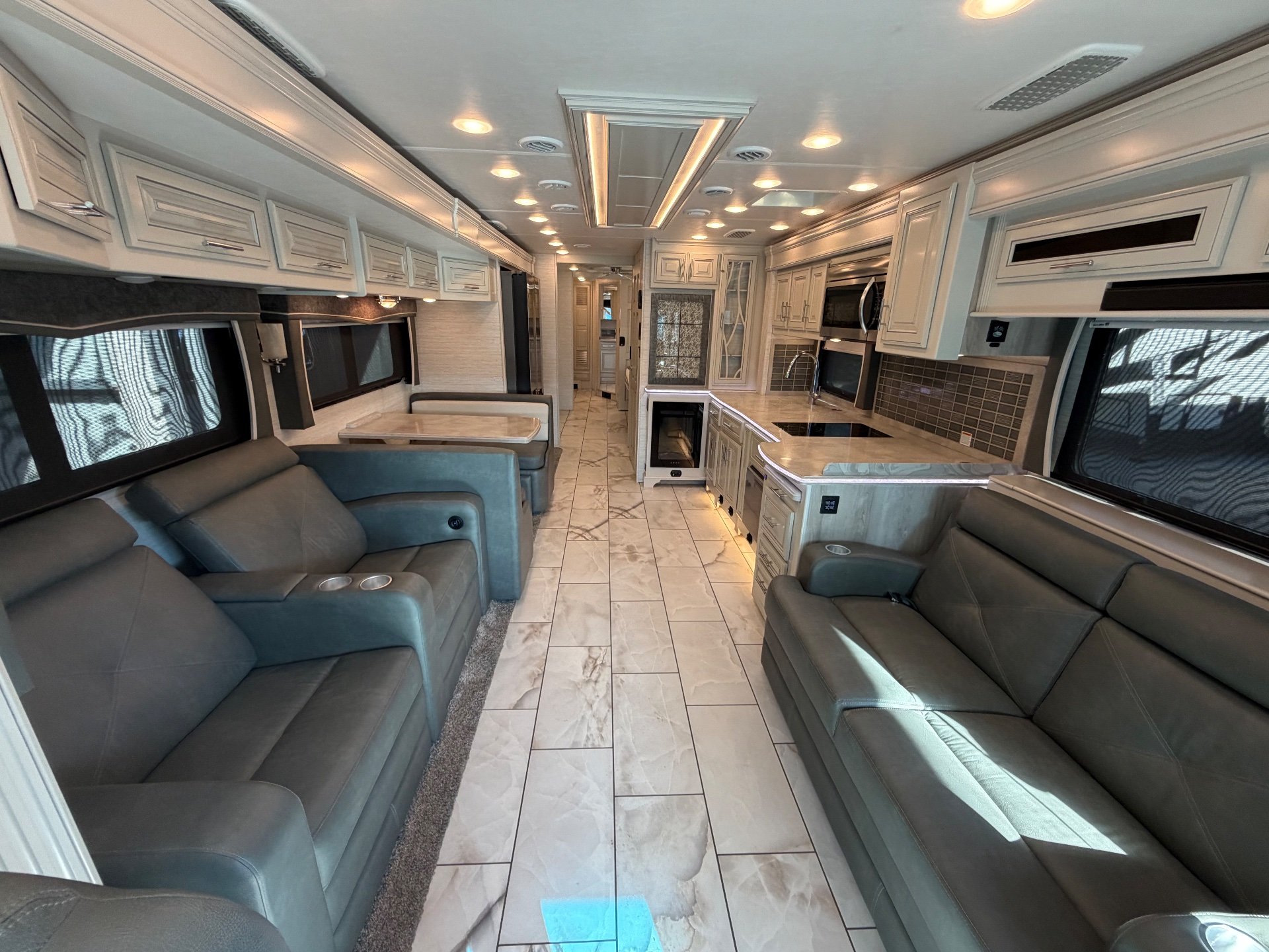 2023 Forest River Berkshire XLT 45E — Class A motorhome overview with sofas, recliners, dinette, kitchen island, cabinetry, and tiled central aisle