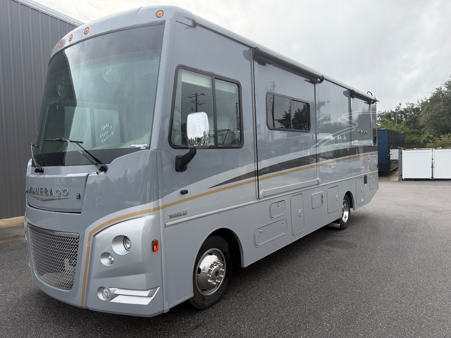 2021 Winnebago Adventurer 27N — The motorhome's front and side exterior, including shell, windows, wheels, and awning