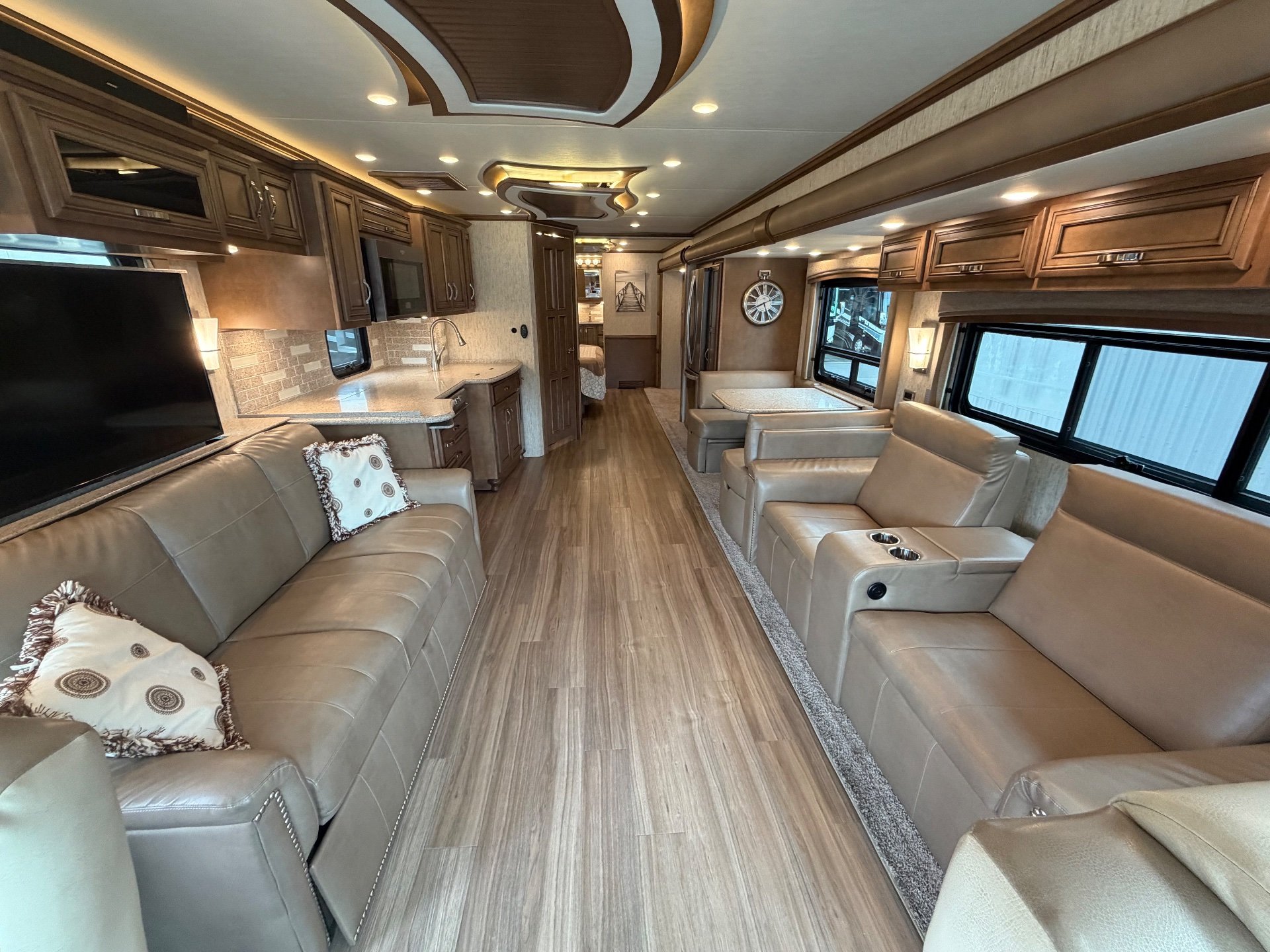 2020 Newmar Kountry Star 4037 — Class A lounge with sofas and recliners, adjacent kitchen counters, and a rear dinette along a central aisle