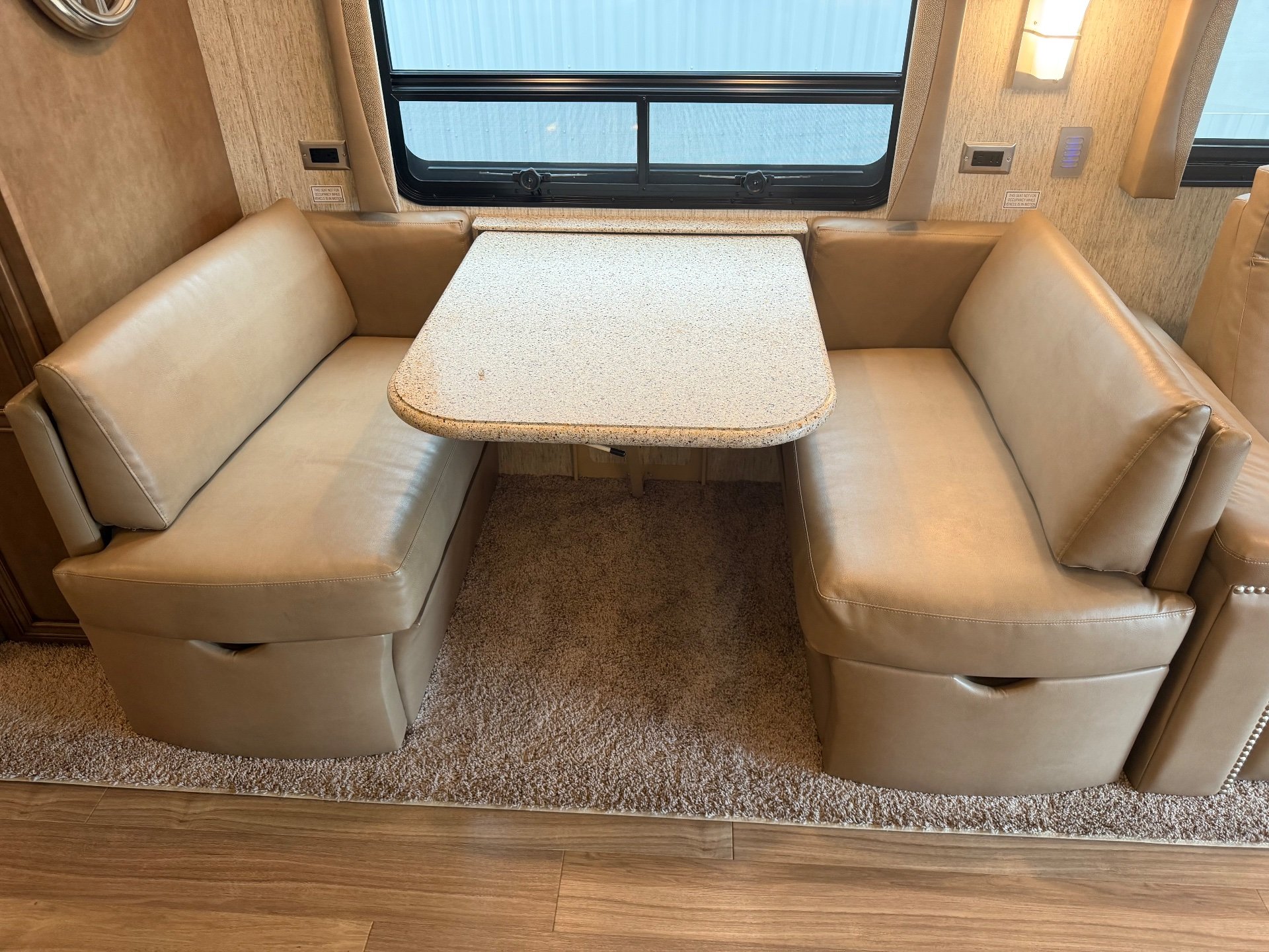 2020 Newmar Kountry Star 4037 — Booth-style dinette with opposing upholstered benches, a rounded rectangular tabletop, and a large window