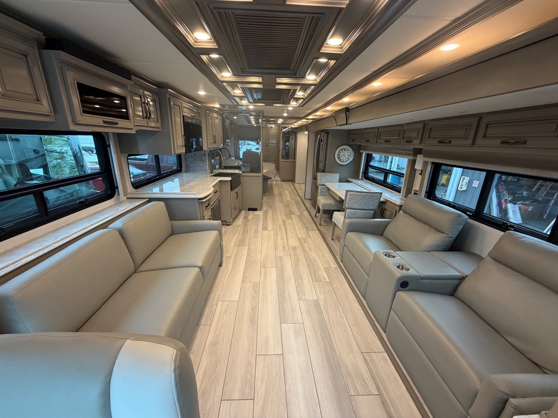 2025 Newmar Dutch Star 4369 — Class A motorhome interior overview with opposing lounge seating, kitchen counters, and a rear dinette