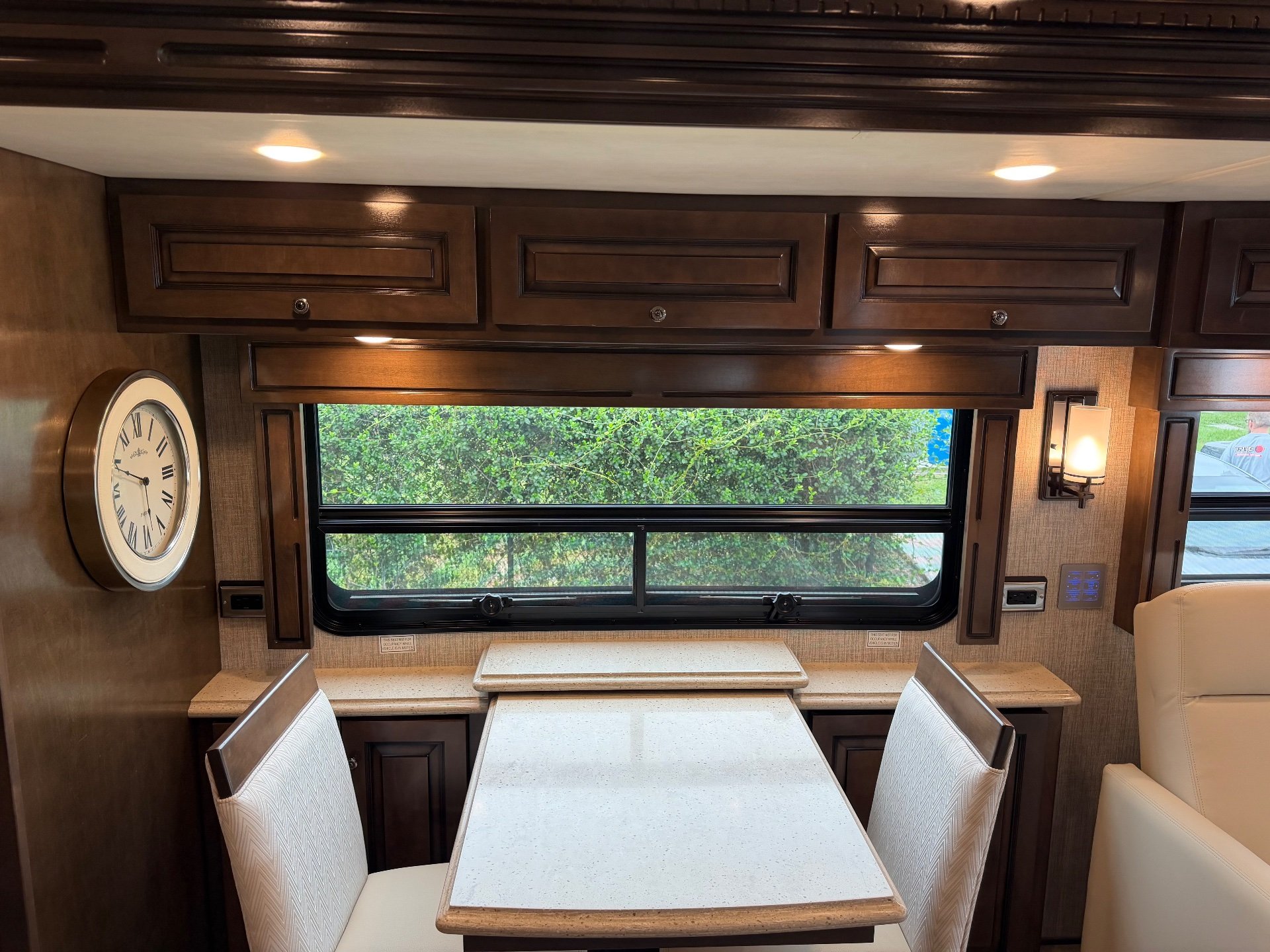 2021 Newmar Dutch Star 4369 — Freestanding dining table and upholstered chairs beneath overhead cabinets and a large window