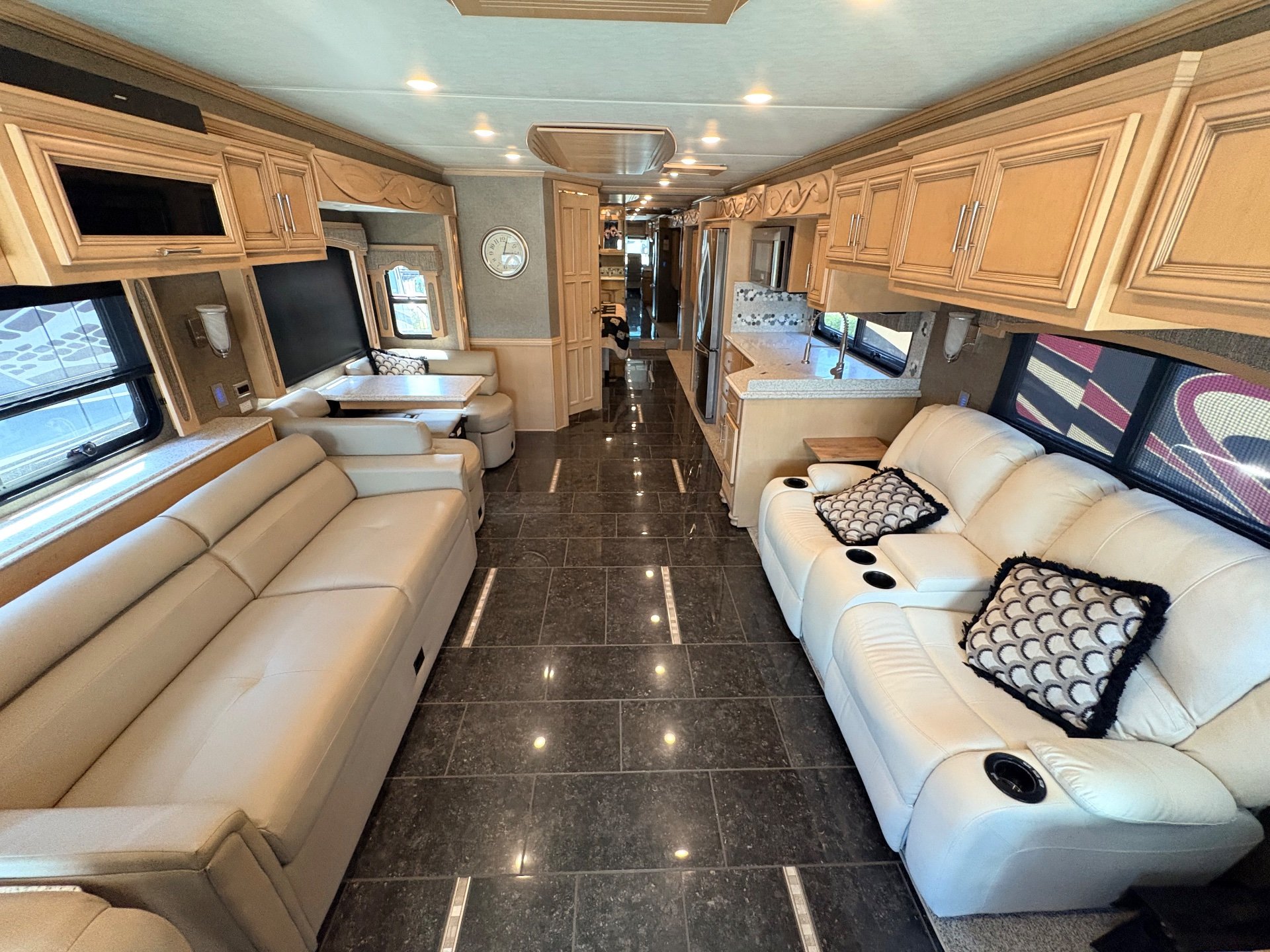 2019 Newmar Ventana 4002 — Class A motorhome interior with opposing recliners, a sofa, dinette, kitchen counter, and central aisle