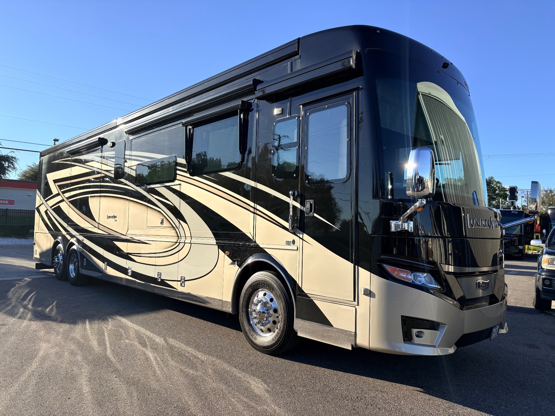 2023 Newmar London Aire 4579 — The outside front and side of a London Aire motorhome, including body shell, wheels, windows, and awning