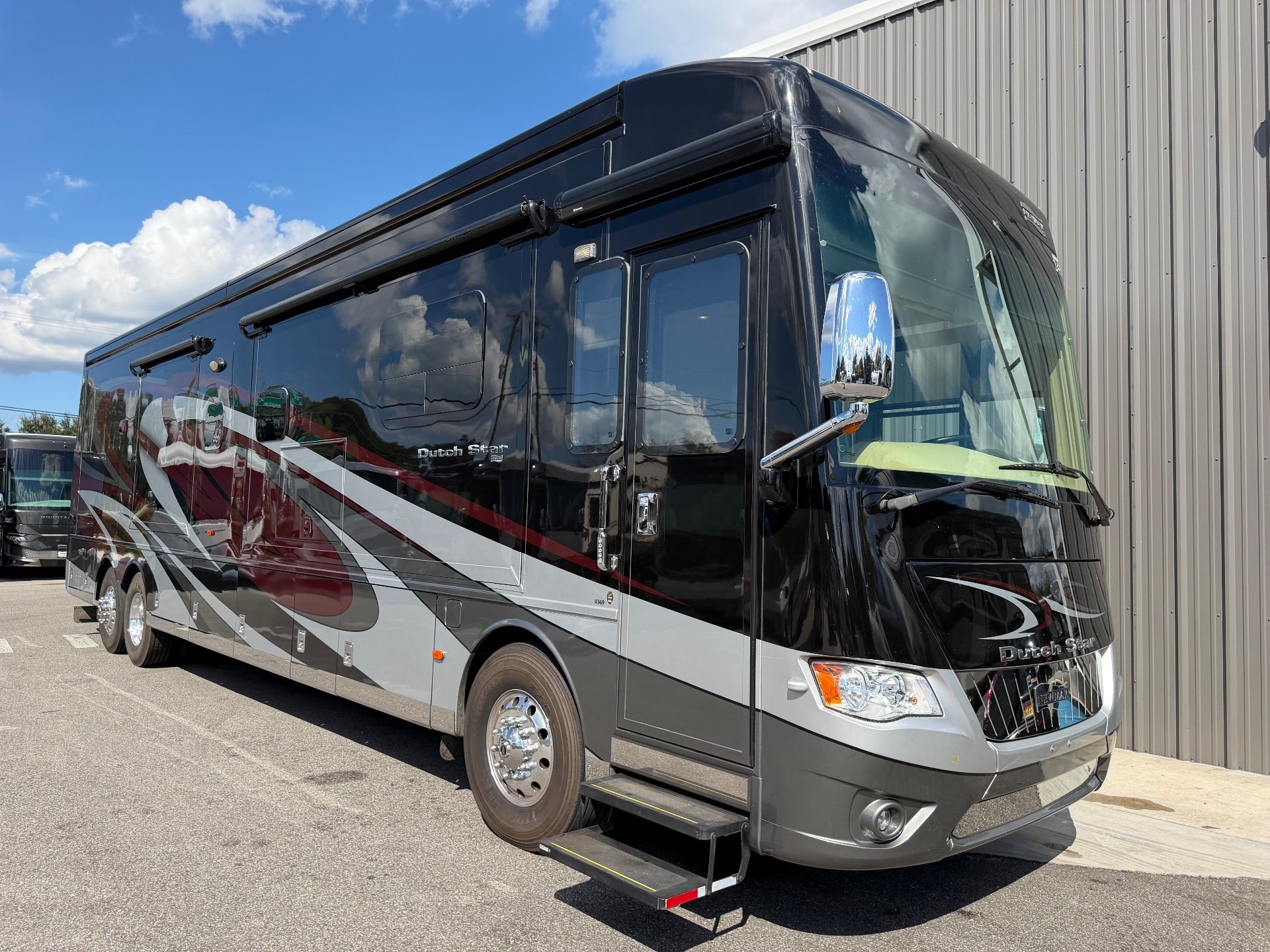 2017 Newmar Dutch Star 4369 — The front and side exterior shell of a Dutch Star motorhome, including wheels, windows, awnings, and entry steps