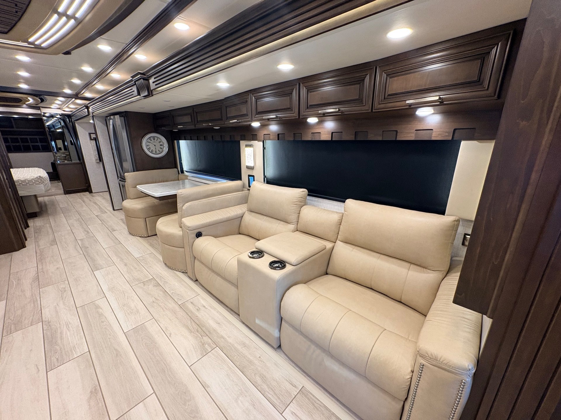 2023 Newmar London Aire 4579 — Class A motorhome lounge with recliners, sofa, overhead cabinets, and adjacent dinette seating