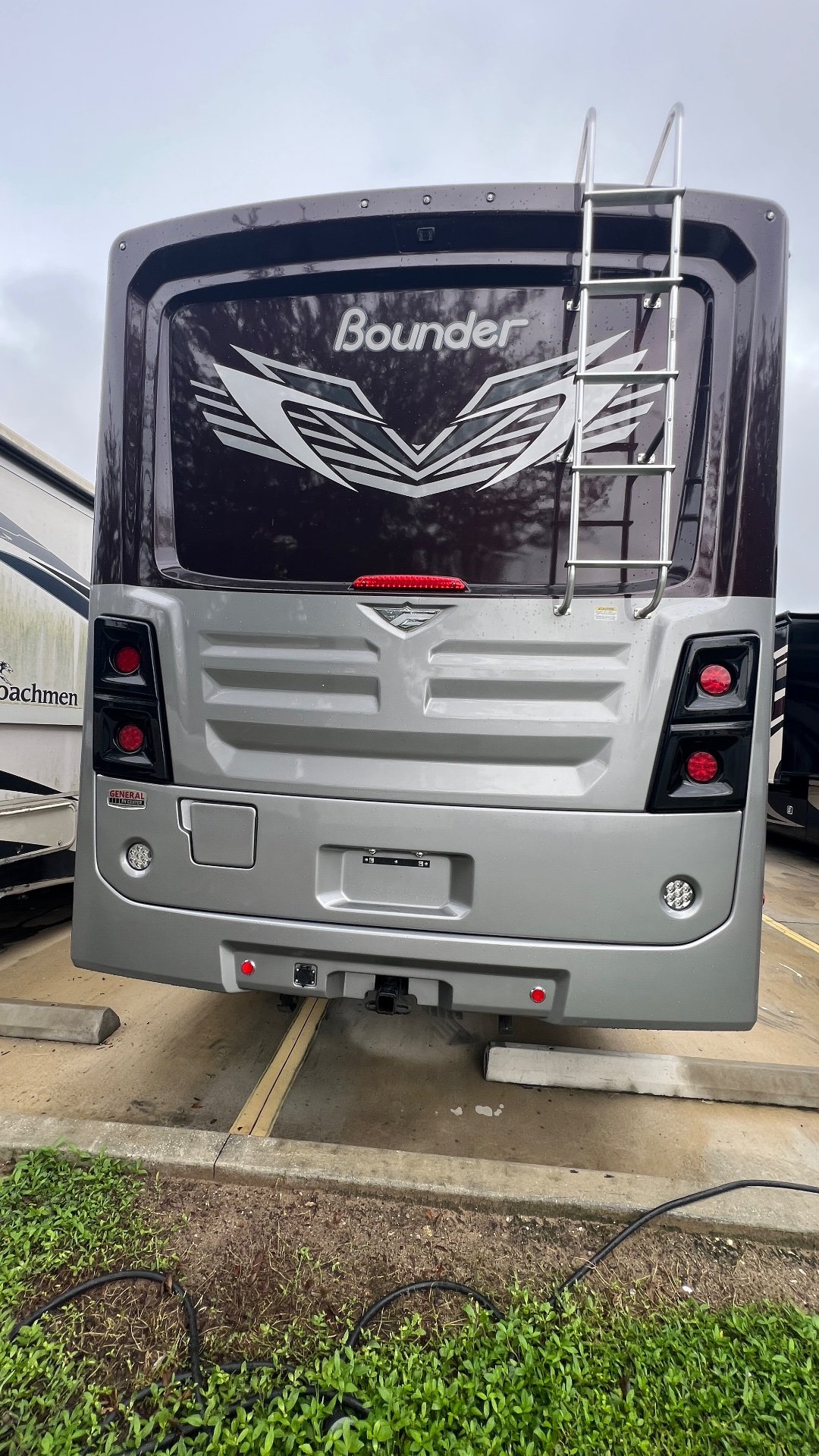 2024 Fleetwood Bounder 35K — The complete rear exterior of the Bounder, including ladder, lights, bumper, and hitch