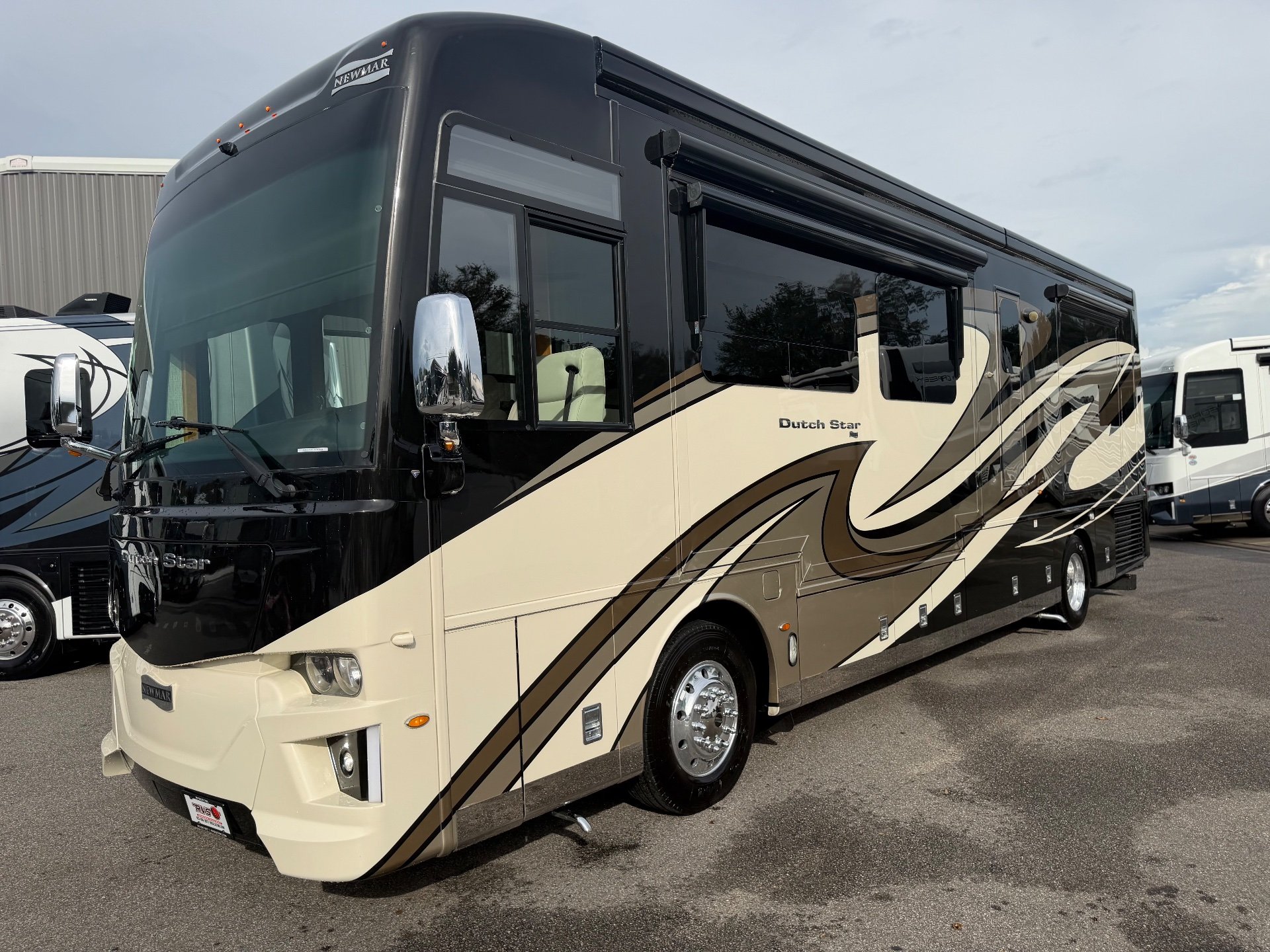 2020 Newmar Dutch Star 3717 — The motorhome's exterior front and passenger-side body, windows, wheel, and slide/awning components