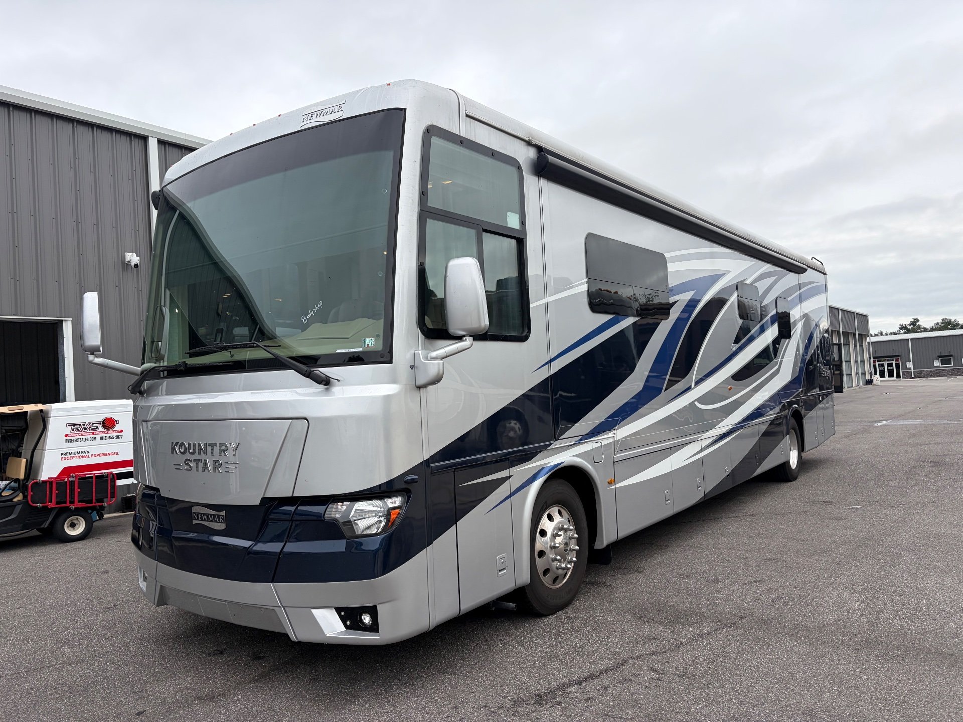 2023 Newmar Kountry Star 4068 — Three-quarter exterior view visibly shows the motorhome shell, front cap, side graphics, windows, and wheel