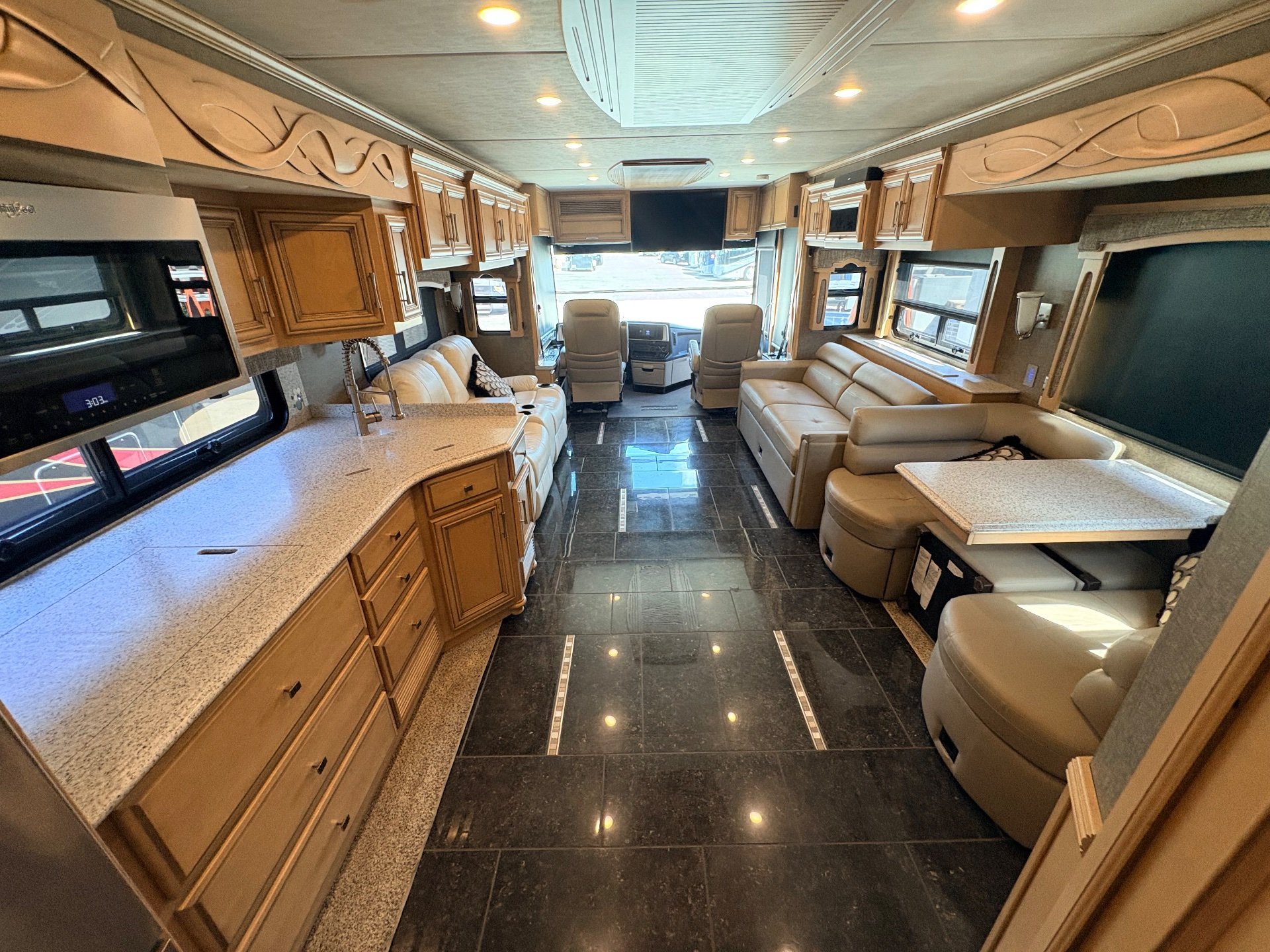 2019 Newmar Ventana 4002 — Class A interior overview with kitchen counter and sink, opposing sofas, dinette, and cockpit