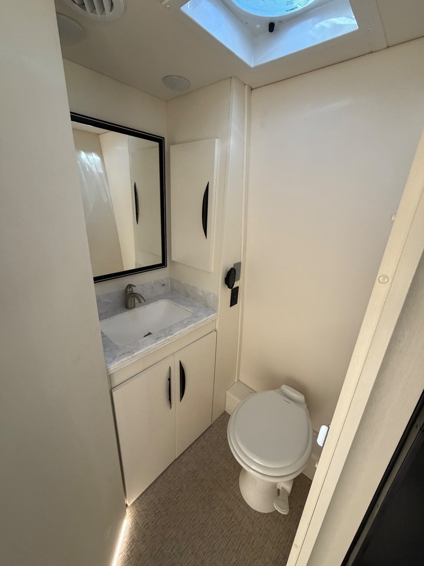 2026 Chinook RV Summit DS — Motorhome bathroom with toilet, vanity sink, mirrored medicine cabinet, and roof vent