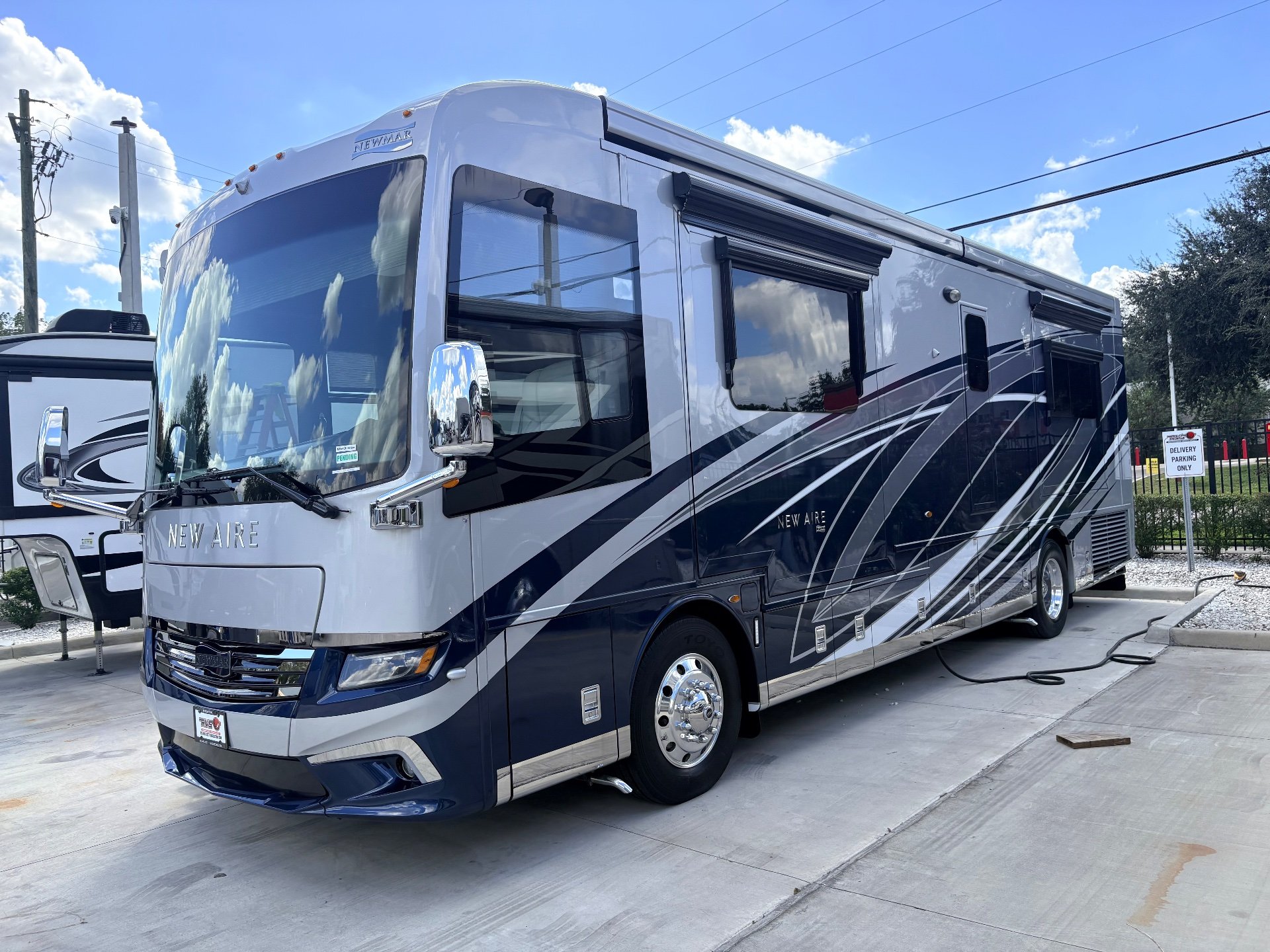 2021 Newmar New Aire 3545 — Front-side exterior photograph clearly shows the complete motorhome body, windshield, wheels, and exterior-installed features