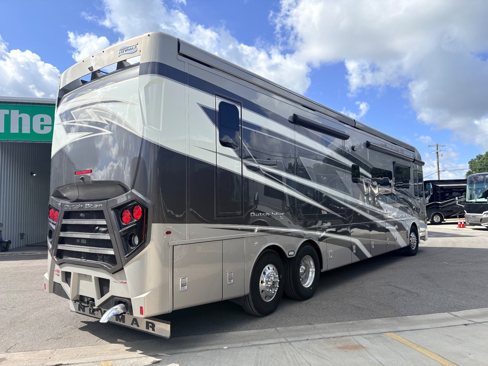 2025 Newmar Dutch Star 4369 — The motorhome's exterior rear and driver side with body panels, windows, wheels, and awnings